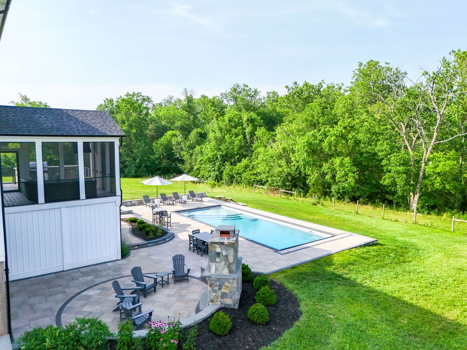 Drone view of an inground fiberglass pool and full paver patio installation by Outdoor Solutions in Northern Virginia